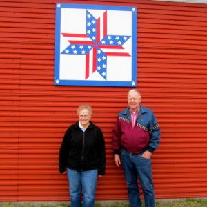 Gary and Rita Stracek with Stars and Stripes Forever barn quilt